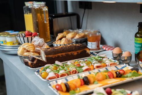 - une table garnie de différents types de pain et de viennoiseries dans l'établissement Hôtel Du Mont Dore Batignolles, à Paris