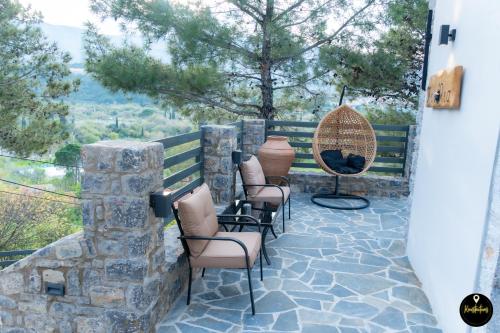 a patio with chairs and a stone wall at Pinolia Rooms in Chios