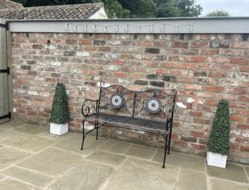 a black bench sitting in front of a brick wall at Moat View FREE PARKING, CENTRAL, EV PLUG in York