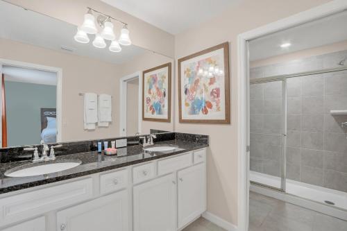 a bathroom with two sinks and a shower at 5532 Misty Oak Circle in Davenport
