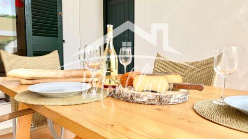 a wooden table with glasses of wine and cheese at SA TORRETA 1 in Cala Blanca