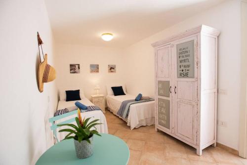 a room with two beds and a table in it at [Pula Is Molas Resort] wi-fi free parking Netflix in Santa Margherita di Pula