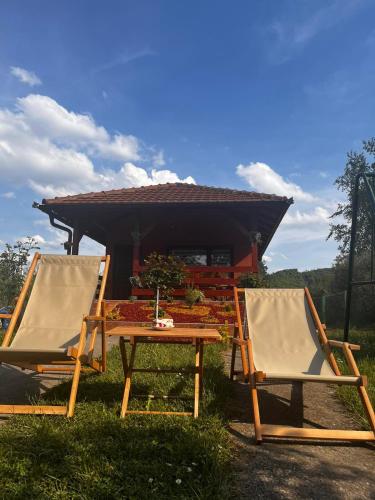 two chairs and a table in front of a house at Studio Vikendica Bele Vode in Banja Koviljača