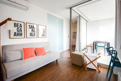 Tabas - VN Ferreira Lobo في ساو باولو: غرفة معيشة مع أريكة بيضاء ووسائد برتقالية