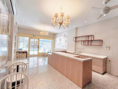 a kitchen with a large island and a chandelier at Elsa House in Tainan