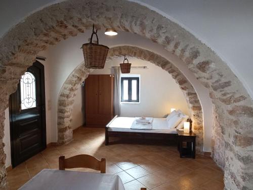 a room with a bed in a stone archway at The Old barrel houses in Kythira