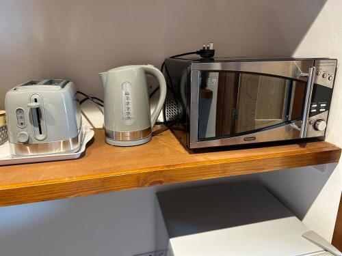 a microwave and a toaster on a wooden shelf at Number 6 in Fort William