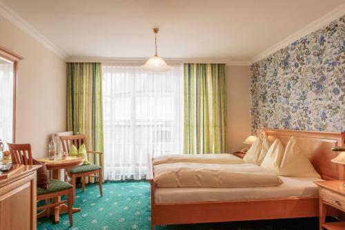 ザンクト・ヴォルフガングにあるHotel Weisser Bärのベッドとデスクが備わるホテルルームです。