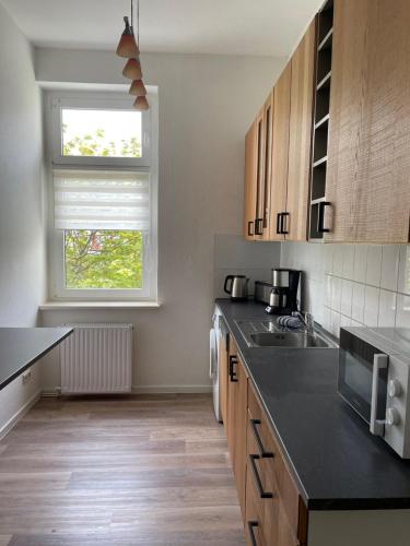 uma cozinha com um balcão preto e uma janela em Apartment am Kino em Bautzen