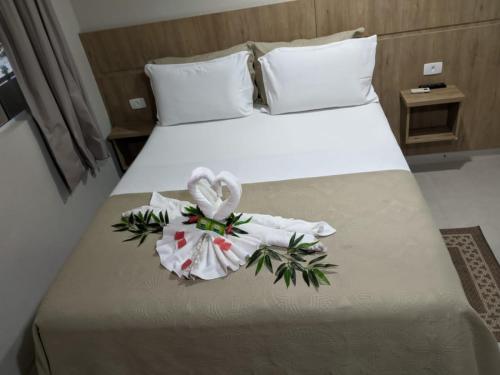 um quarto de hotel com uma cama com duas toalhas em Pousada Mar e Cia na Ilha do Mel