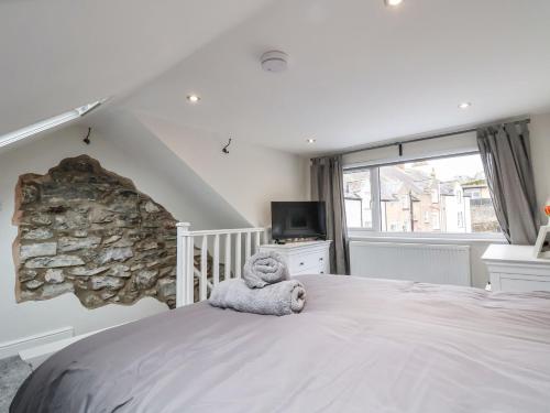 a stuffed teddy bear sitting on a bed in a bedroom at 4 Railway Terrace in Conwy