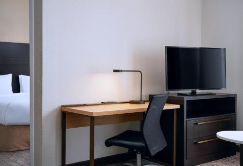 a desk with a television and a chair in a hotel room at Residence Inn Fort Lauderdale SW/Miramar in Miramar
