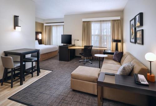 een hotelkamer met een bank, een bed en een bureau bij Residence Inn Fort Lauderdale SW/Miramar in Miramar