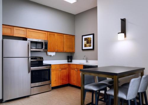 a kitchen with wooden cabinets and a table with chairs at Residence Inn Fort Lauderdale SW/Miramar in Miramar