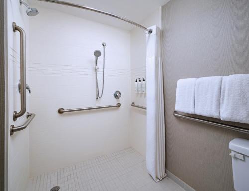 a bathroom with a shower and a toilet and towels at Residence Inn Fort Lauderdale SW/Miramar in Miramar