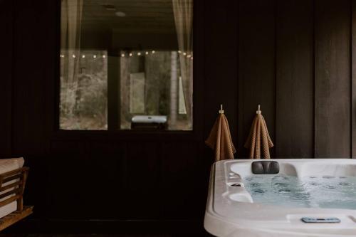 a bathroom with a white sink and a mirror at Unwind in Style & Serenity - The Denizen in Broken Bow