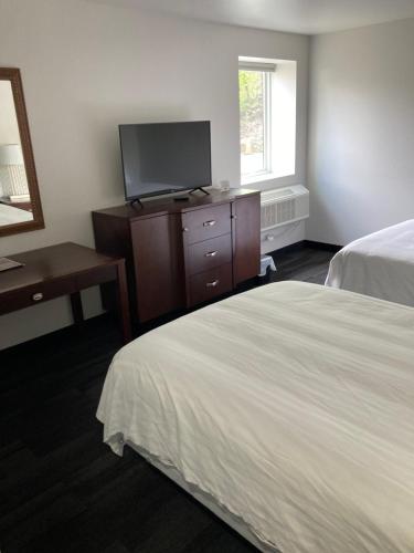 a hotel room with two beds and a flat screen tv at Elker Inn & Suites in Ridgway