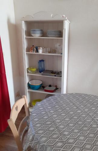 Cette chambre comprend une table et une étagère avec de la vaisselle. dans l'établissement Studio intra-muros 5mn gare centre, à Avignon