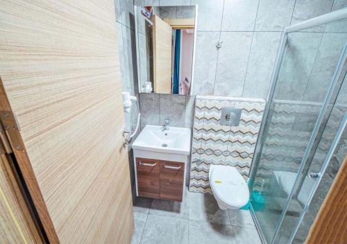 y baño con lavabo, aseo y espejo. en Nehir Suite Hotel en Uzungol