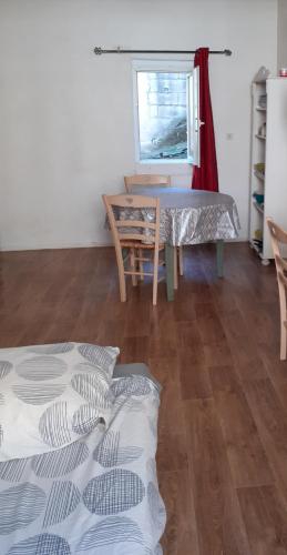 un salon avec une table et une fenêtre dans l'établissement Studio intra-muros 5mn gare centre, à Avignon
