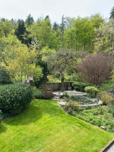 a garden with green grass and a pond at Ferienhof Kröger in Bielefeld