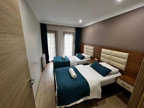 ウズンギョルにあるNehir Suite Hotelのベッドルーム1室(ベッド2台、青と白の枕付)