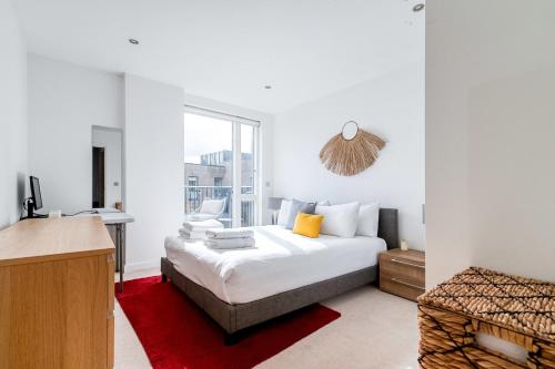 Modern Bermondsey Apartment في لندن: غرفة نوم بيضاء بها سرير ونافذة