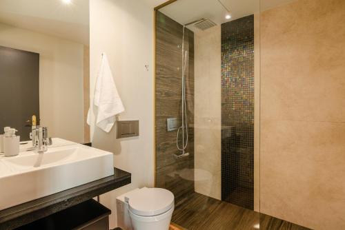 a bathroom with a toilet and a sink and a shower at Calheta Tangerine House in Arco da Calheta