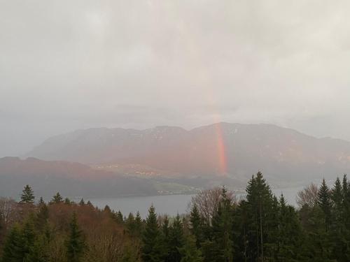 a rainbow over a mountain with a lake and trees at moderne Apartments am Attersee Dachsteinblick - ruhige Lage mit traumhaften Blick in Nussdorf am Attersee