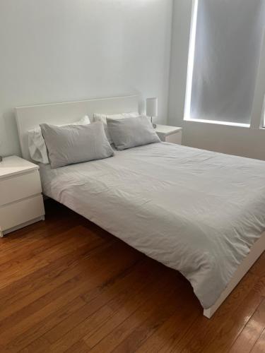 a bed with white sheets and pillows in a bedroom at Adorable 2 bedroom with free street parking in Chicago