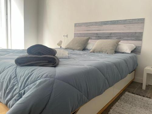 1 dormitorio con 1 cama grande con sábanas y almohadas azules en Piso en el centro del Vendrell. Alojamiento entero., en El Vendrell