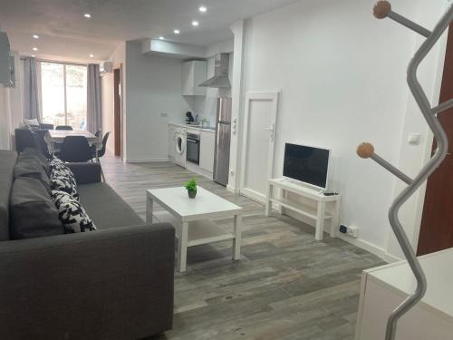 a living room with a couch and a tv at Piso en el centro del Vendrell. Alojamiento entero. in El Vendrell