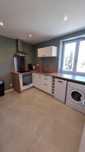 - une cuisine équipée d'un lave-linge, d'un évier et d'une cuisinière dans l'établissement En plein coeur de Pélissanne - 55 m2 rénovés - Avec Parking, à Pélissanne