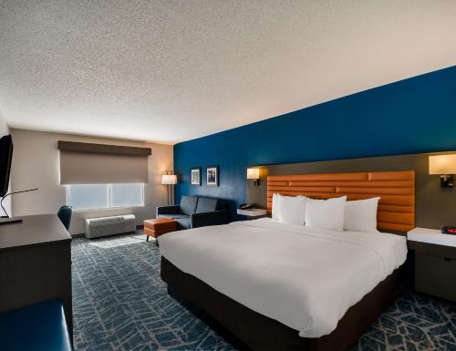 Cette chambre comprend un grand lit et un mur bleu. dans l'établissement Comfort Inn Falls Church - Tysons Corner, à Falls Church