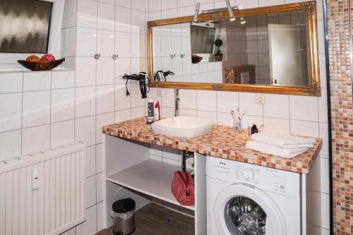 a bathroom with a sink and a washing machine at Ferienwohnung Harländer in Petersdorf auf Fehmarn