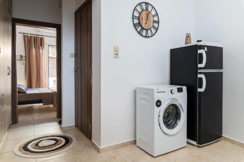 a room with a washing machine and a refrigerator at Appartamento Mare calmo-Myrtos in Myrtos