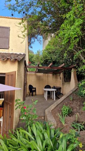 d'une terrasse avec une table et un banc dans une cour. dans l'établissement Villa Terra Bella, à Grosseto-Prugna