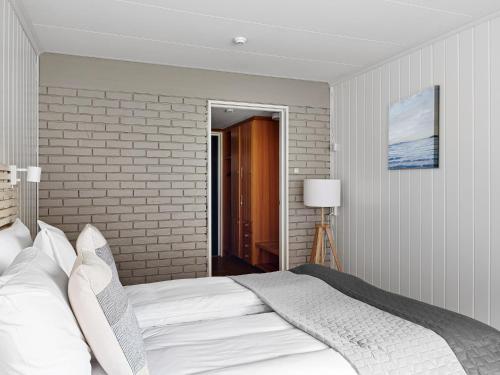 a bedroom with a bed and a brick wall at Eidfjord Hotel in Eidfjord