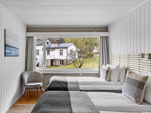 Eidfjord Hotel في إيدفيورد: غرفة نوم بسريرين ونافذة كبيرة