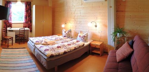 1 dormitorio con 1 cama y 1 sofá en Tuukkalan Tila B&B, en Ristiina