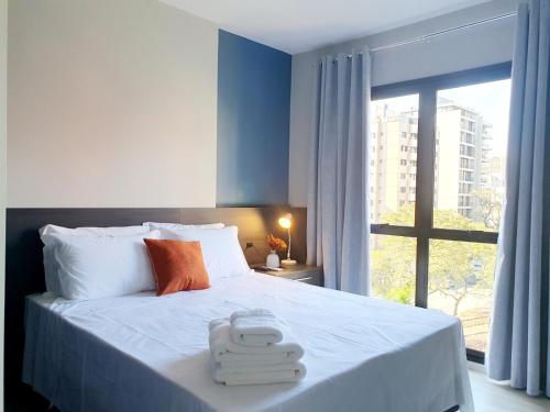 a bedroom with a bed with two towels on it at Dois quartos condomínio clube de luxo Sky com vaga in Curitiba
