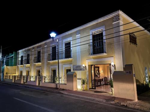 a white building on a street at night at Hotel Fundadores in Valladolid