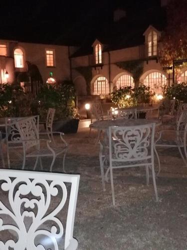a group of chairs and tables in a courtyard at night at Luxury 4 bedroom Lodge Mount Juliet Estate Thomastown Kilkenny in Thomastown
