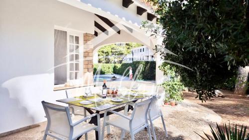 a table and chairs on a patio with an archway at VILLA LORENZo in Cala Blanca