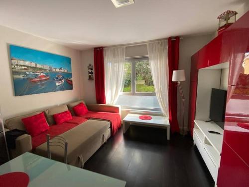 un soggiorno con letto e divano rosso di Apartamento de playa familiar, piscina y garaje. a Ares