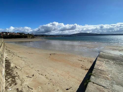 a view of a beach with the water and sky at Apartamento de playa familiar, piscina y garaje. in Ares