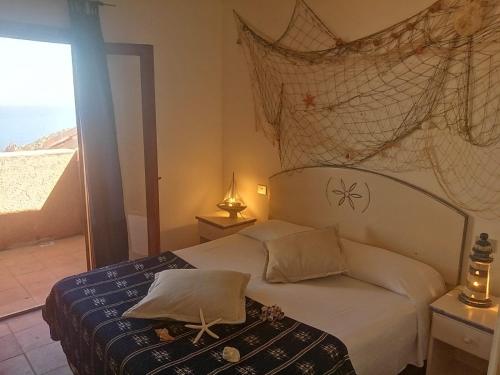Schlafzimmer mit einem Bett und Meerblick in der Unterkunft Villetta Susy in Costa Paradiso