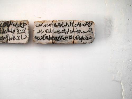 Una pared con dos piezas escritas. en Patio De La Luna, en Asilah