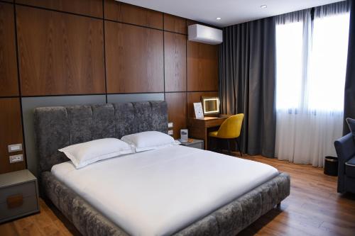 a bedroom with a large white bed and a desk at The Wilson Tirana in Tirana