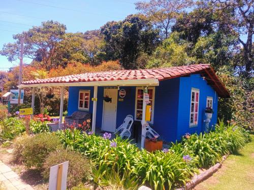 una pequeña casa azul con techo rojo en Hospedaje Santaelena -chalets de montaña- en Santa Elena